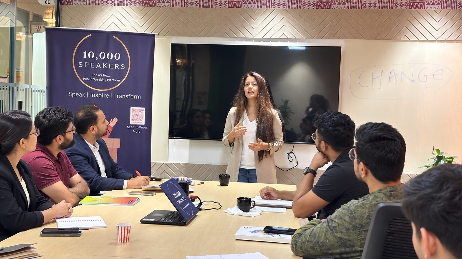 A trainer leading a 10,000 Speakers session with a group of working professionals